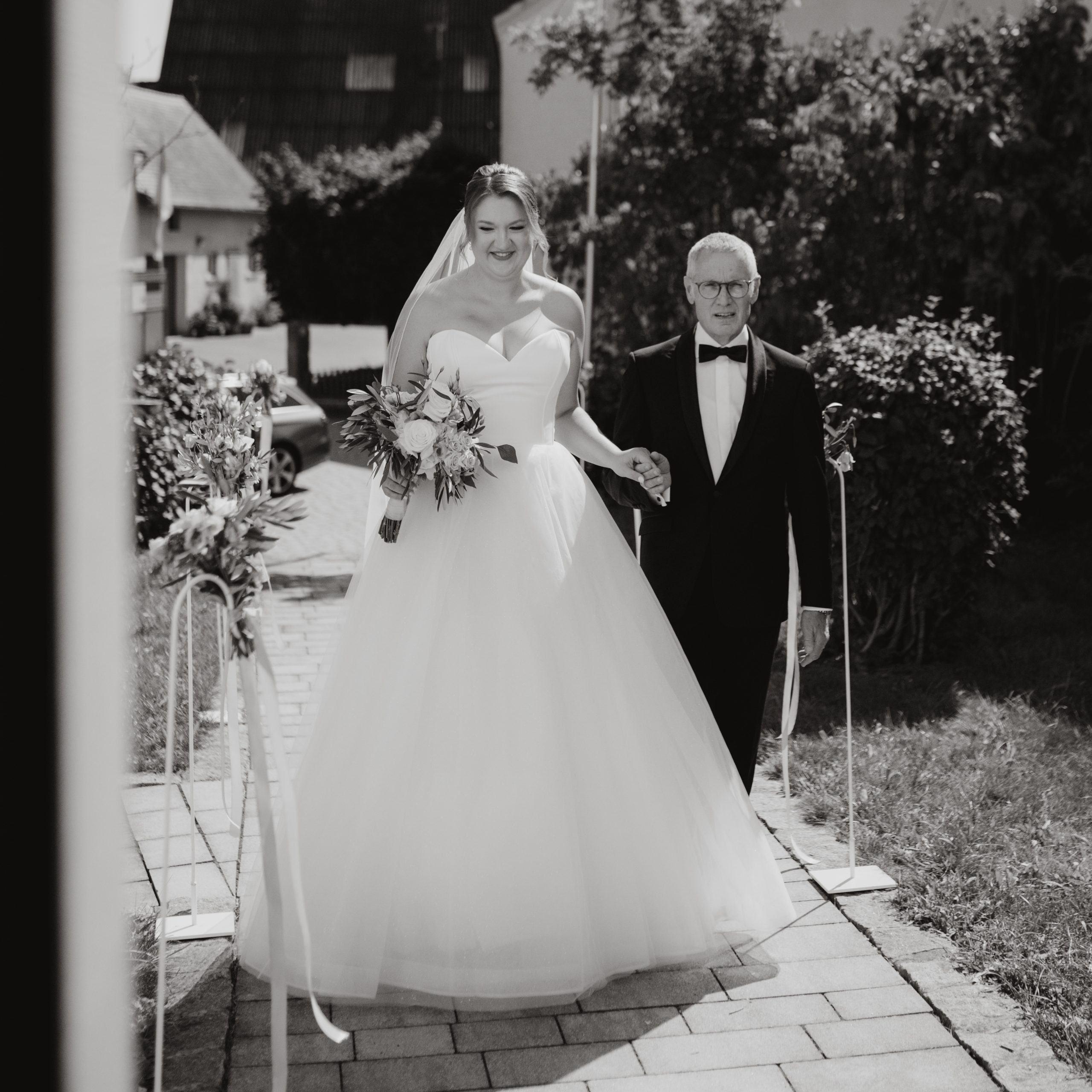 Braut wird von Vater zum Altar gebracht