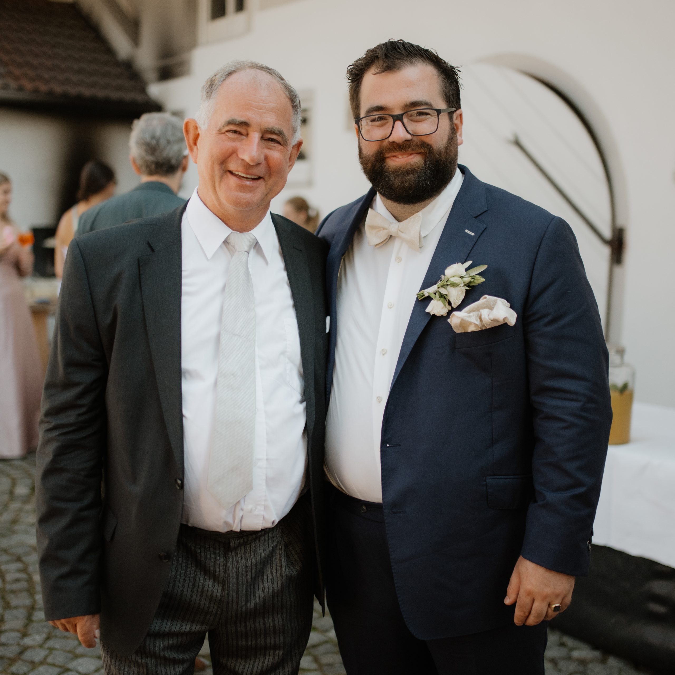 Groom and Dad standing arm in arm