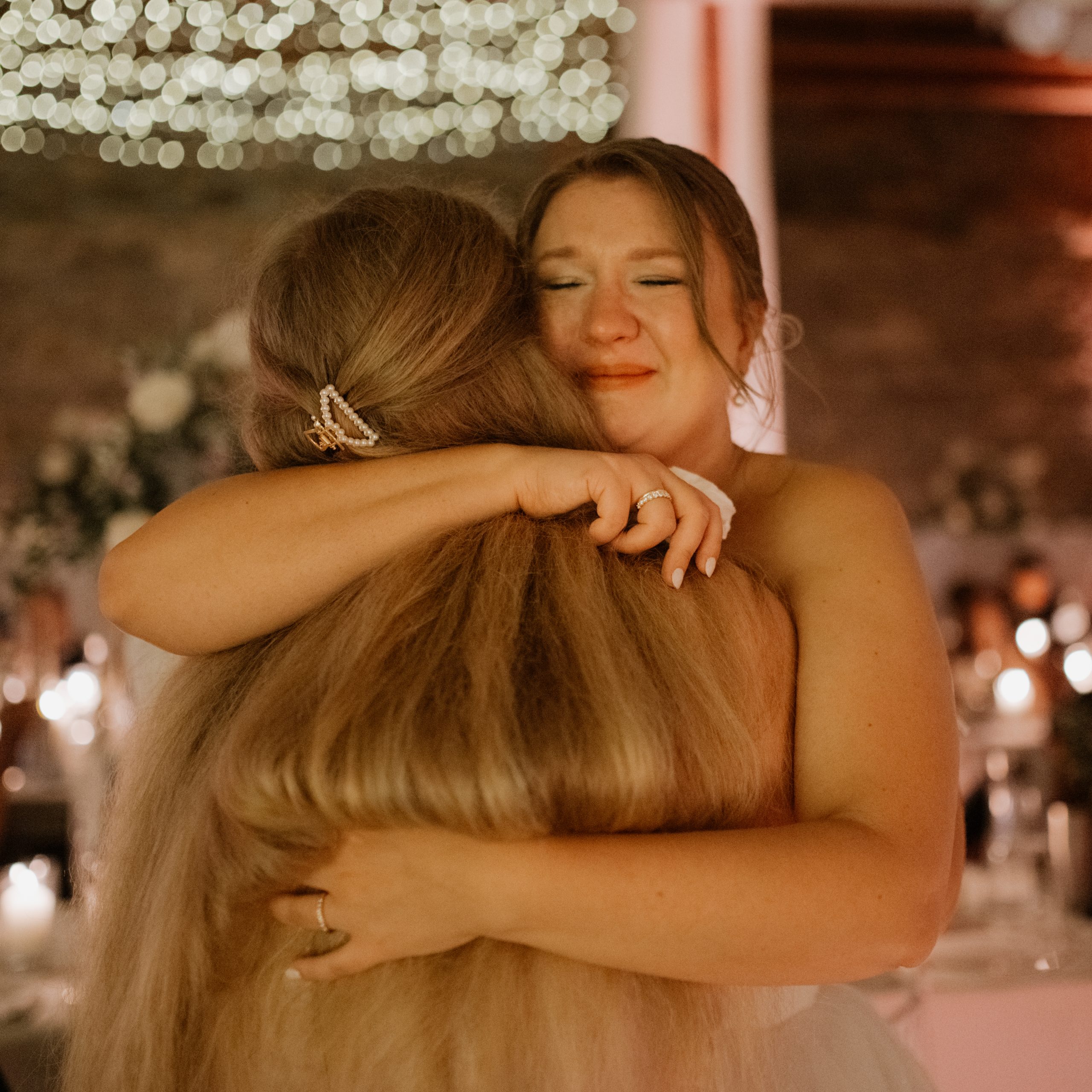 emotionales Bild, Braut ist sehr gerührt und umarmt ihre Schwester