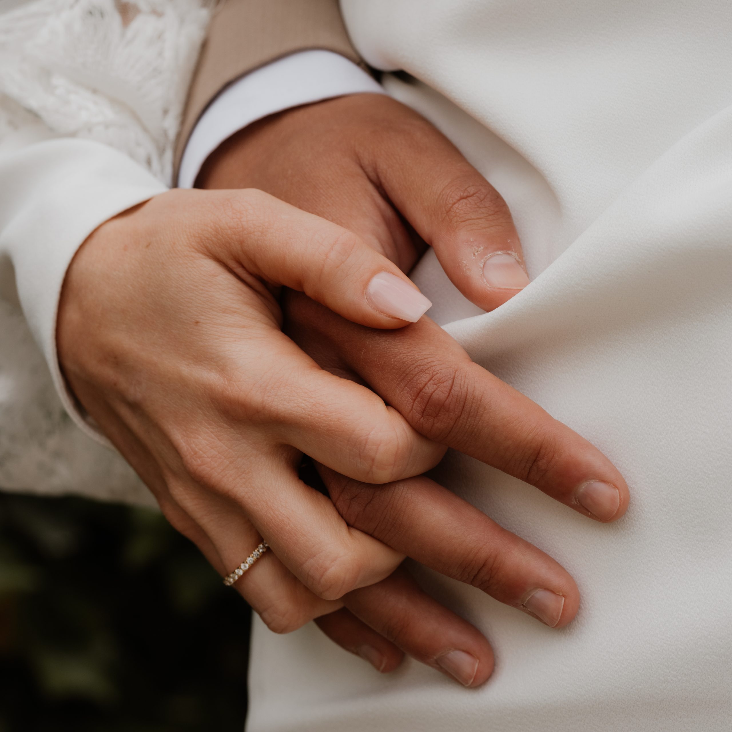 ineinandergreifende Hände von Hochzeitspaar, Nahaufnahme