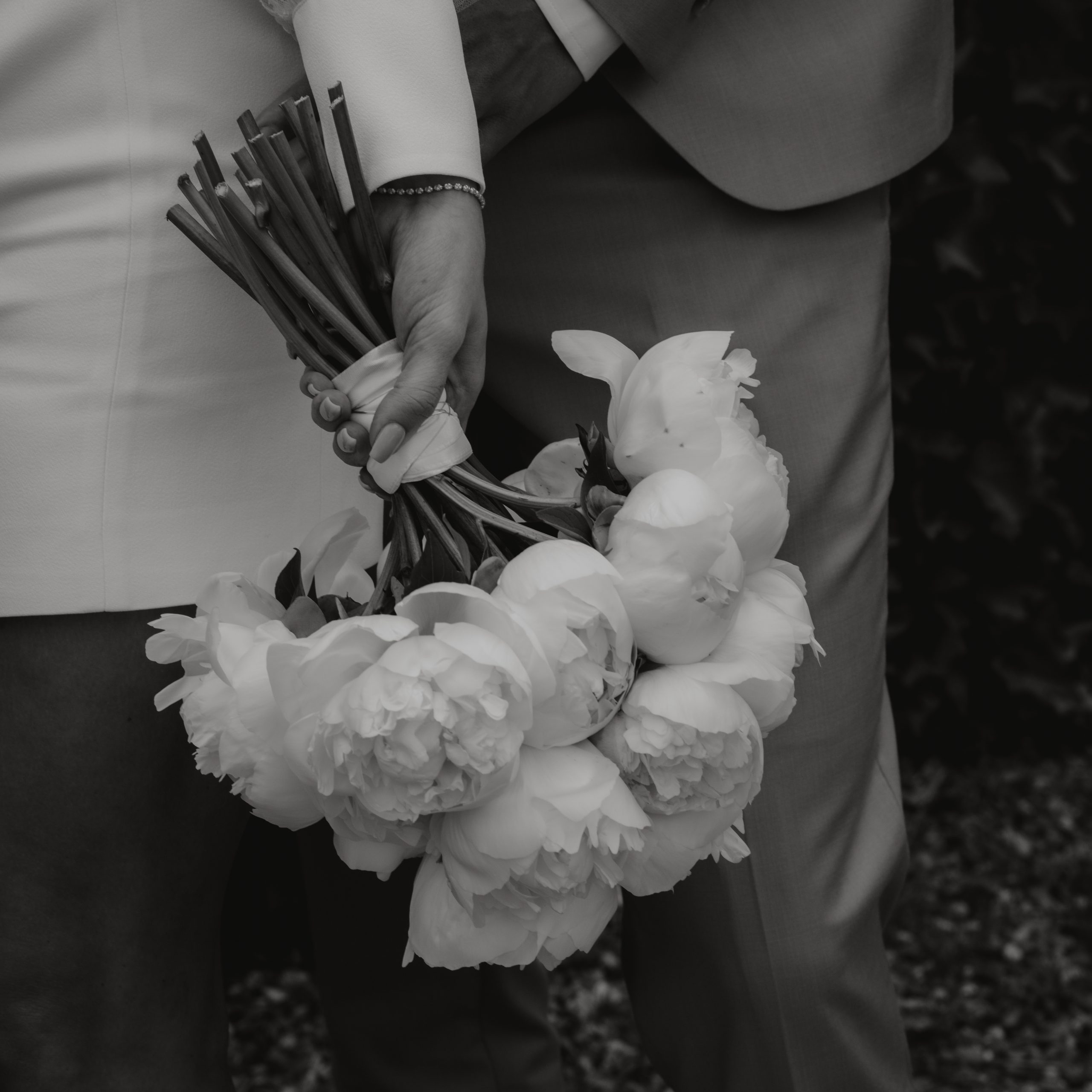 Hochzeitspaar mit Hochzeitsstrauß als Nahaufnahme, in schwarz-weiß
