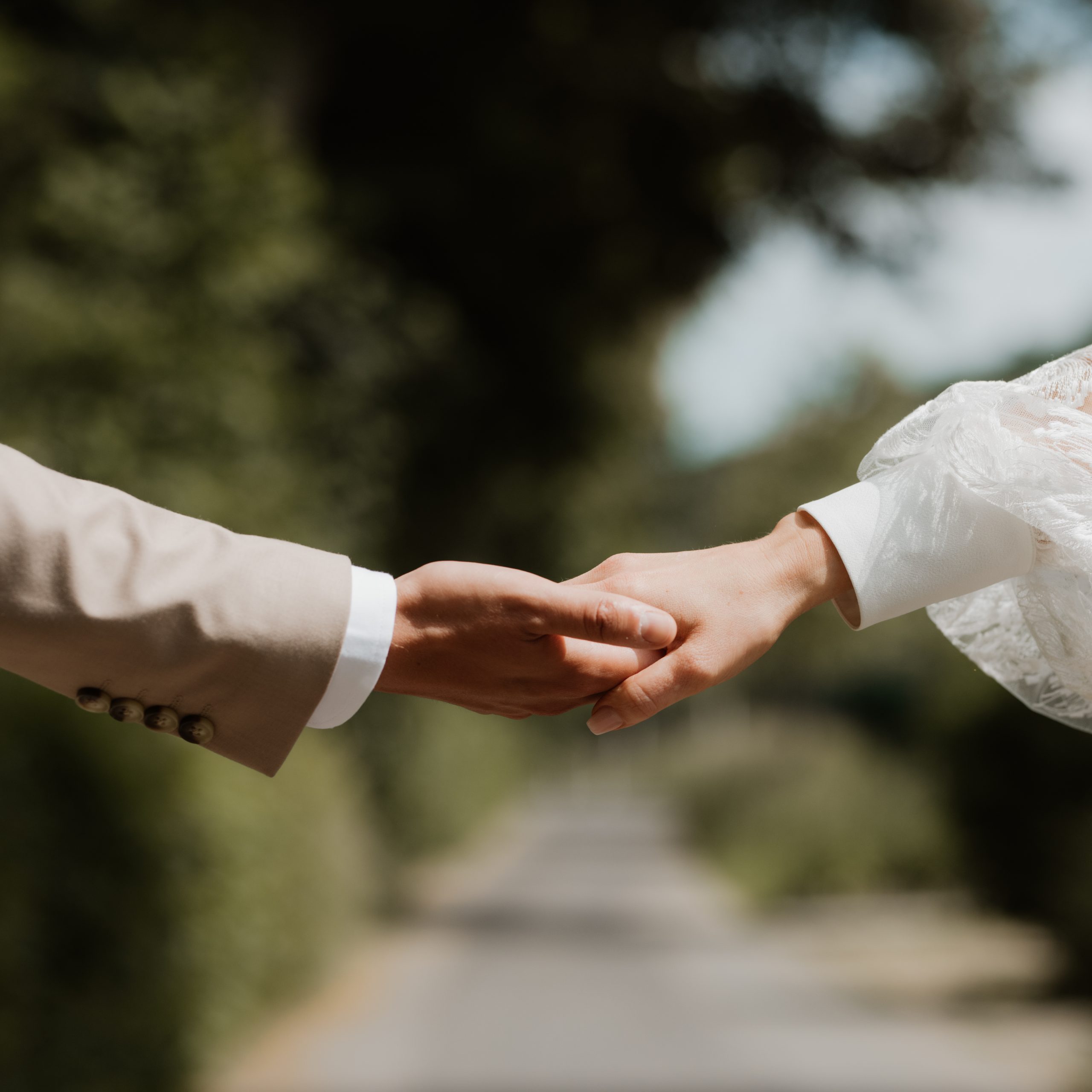Hände von Hochzeitspaar, die ineinander greifen