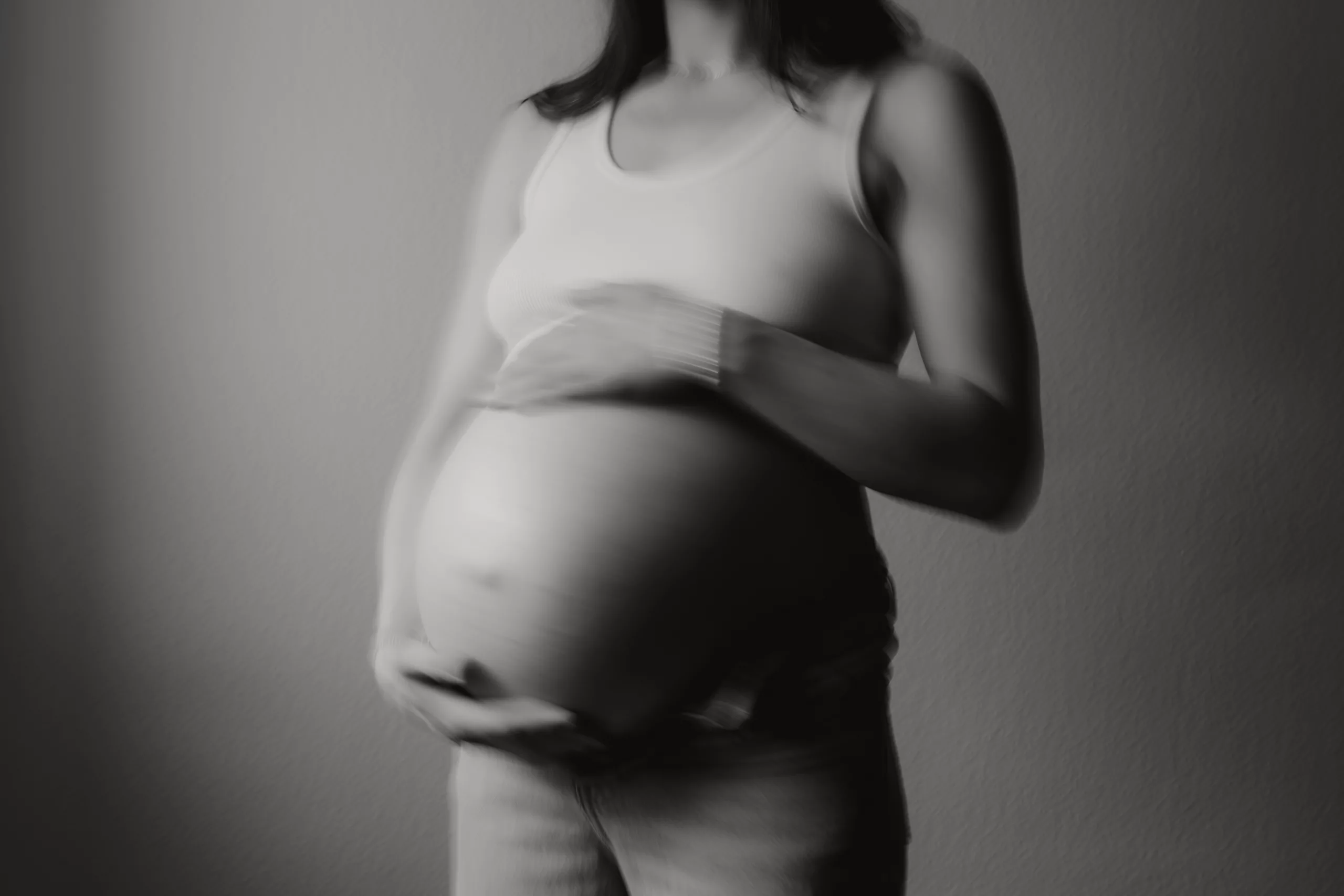 unscharfes, dynamisches, ästhetisches Bild von schwangerem Bauch