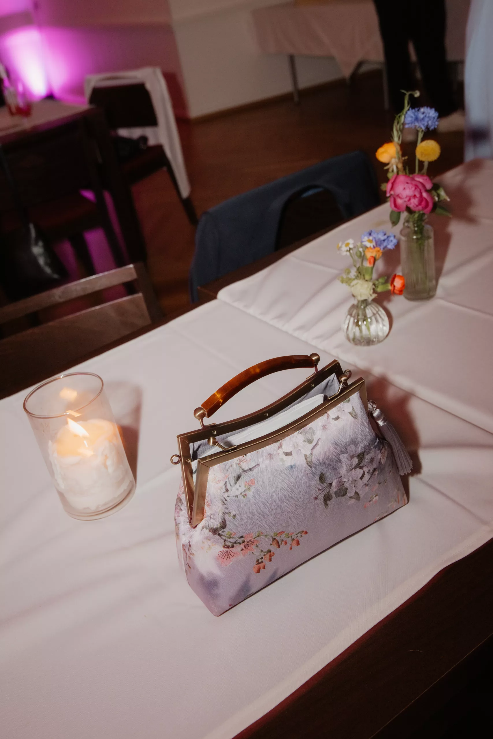 Partyfoto, Detailbild von Tischstillleben, Tasche steht auf Tisch
