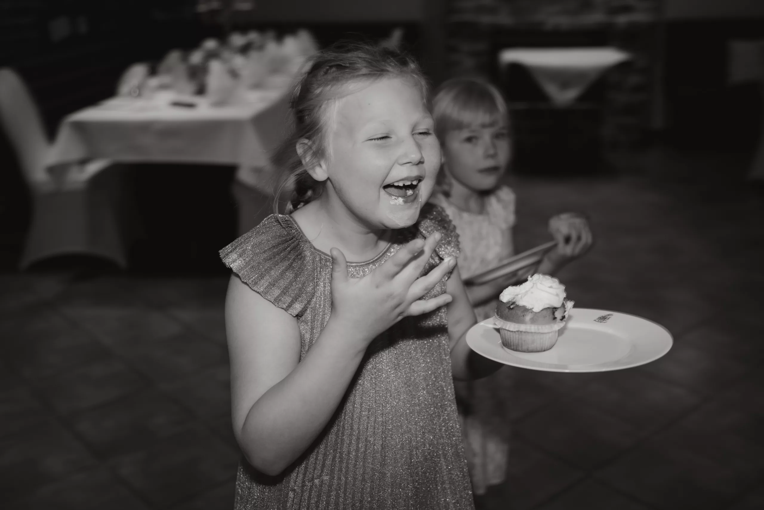 Kinder lachen während sie Kuchen essen und den Mund verschmiert haben