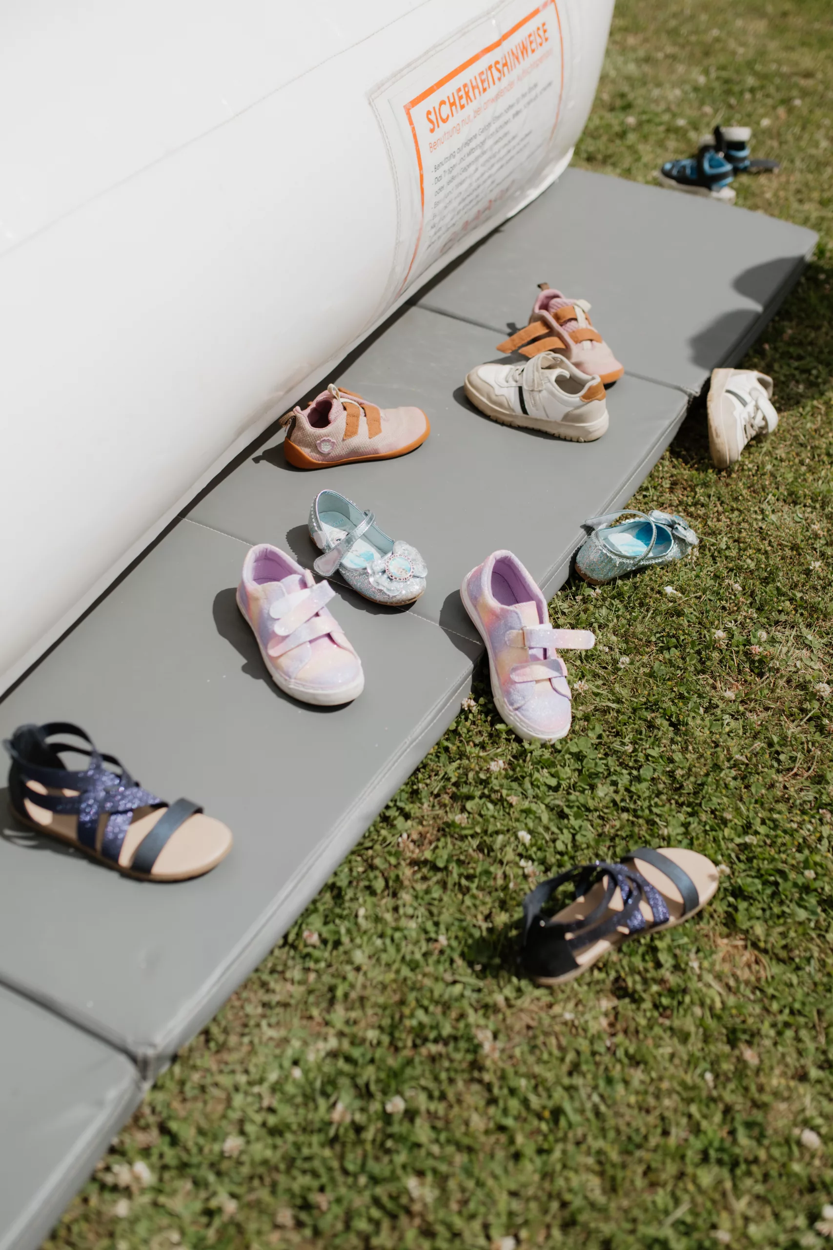 Detailshot von Kinderschuhen vor Hüpfburg während Hochzeit