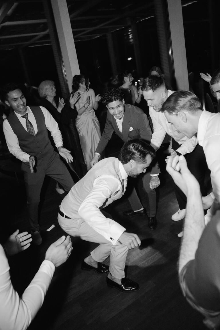 Hochzeitsparty, Bräutigam ist umzingelt von Hochzeitsgästen und tanzt