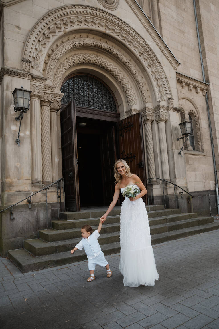 Braut mit Kind vor Kirche
