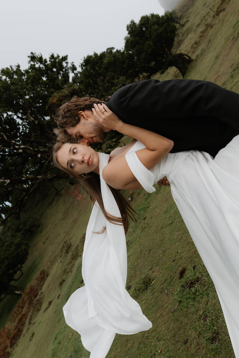 Brautpaar, editorial, steht vor dramatischer Kulisse im Fanal Forrest in Madeira