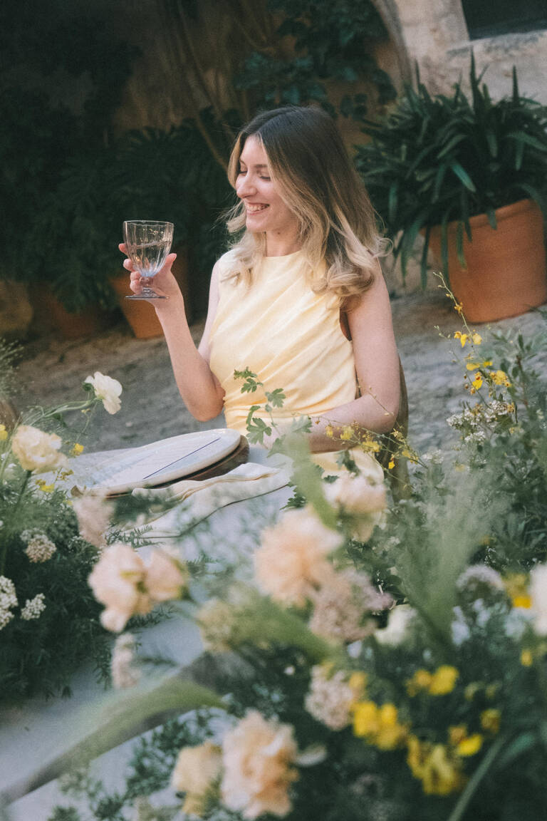 Gast erhebt Glas, Abendstimmung von einem mit Blumen geschmückten Hochzeitstisch in einer Finca auf Mallorca, Son Burget Villa