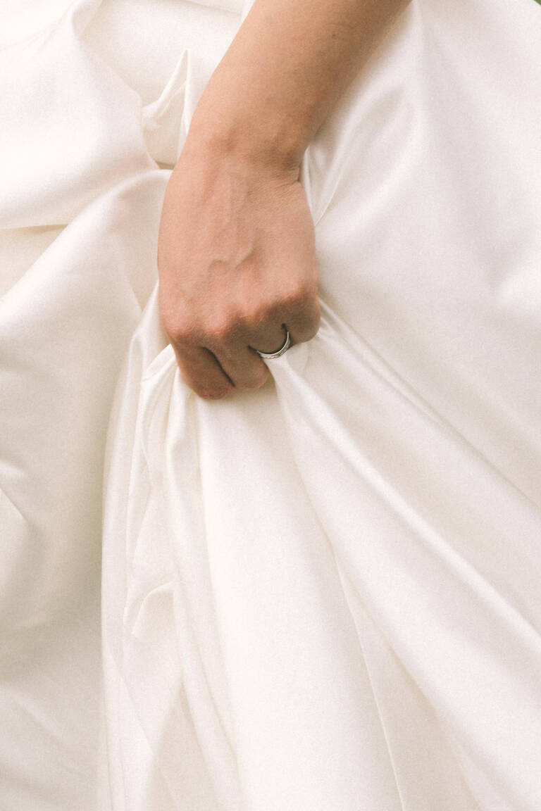 Detailfoto von Hand, das Brautkleid hält