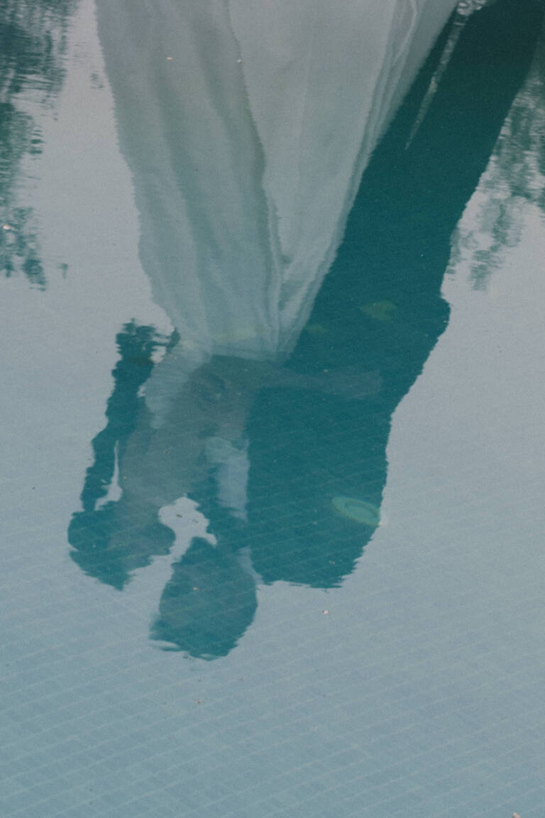 Brautpaar küsst sich, Spiegelung im Pool der beiden